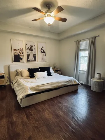 a bedroom with a large bed and a chandelier