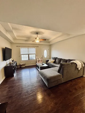 a living room with furniture and a wooden floor