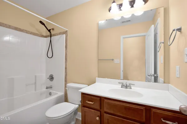 a bathroom with a granite countertop sink a toilet and shower