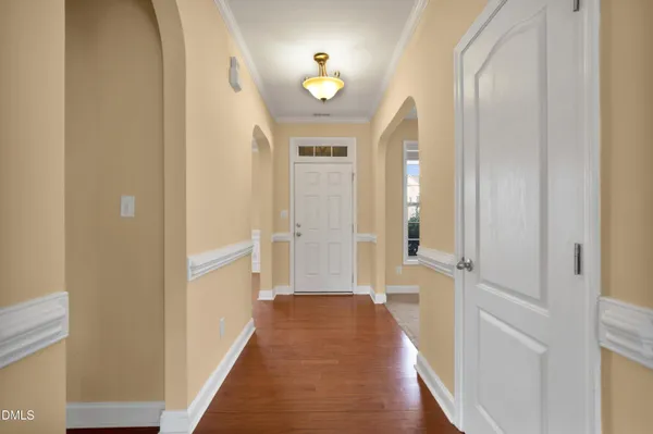 a view of a hallway with wooden floor and staircase