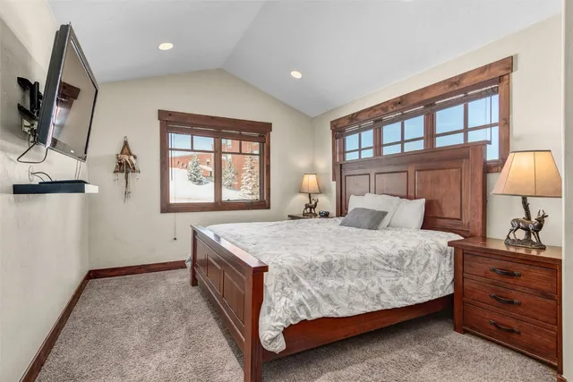 a bedroom with a bed a mirror on dresser and a window