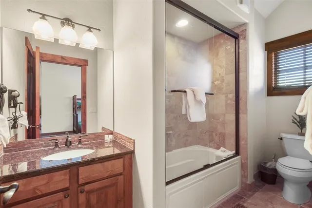 a bathroom with a granite countertop sink toilet and shower
