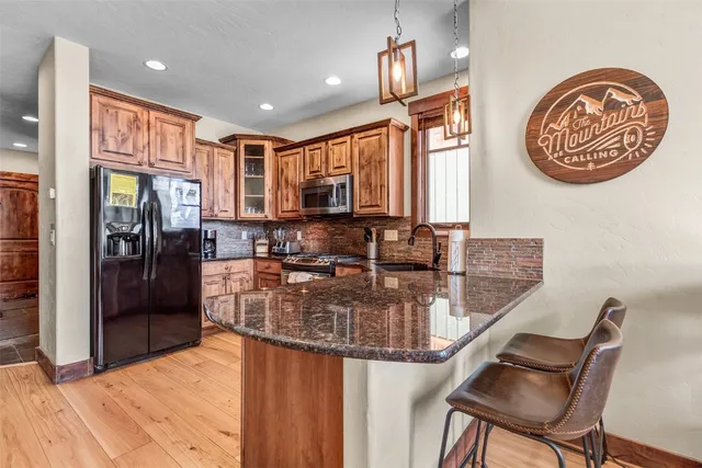 a kitchen with stainless steel appliances granite countertop a sink refrigerator and cabinets
