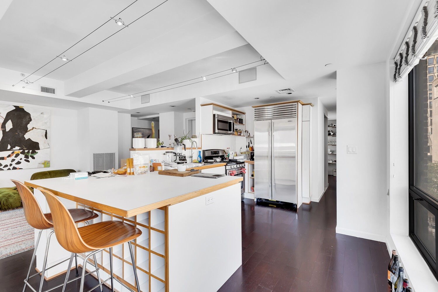 334 Grand Street, Unit PH Manhattan, NY 10002 - Photo 2 of 14 a kitchen with stainless steel appliances a refrigerator a stove a sink dishwasher and white cabinets with wooden floor