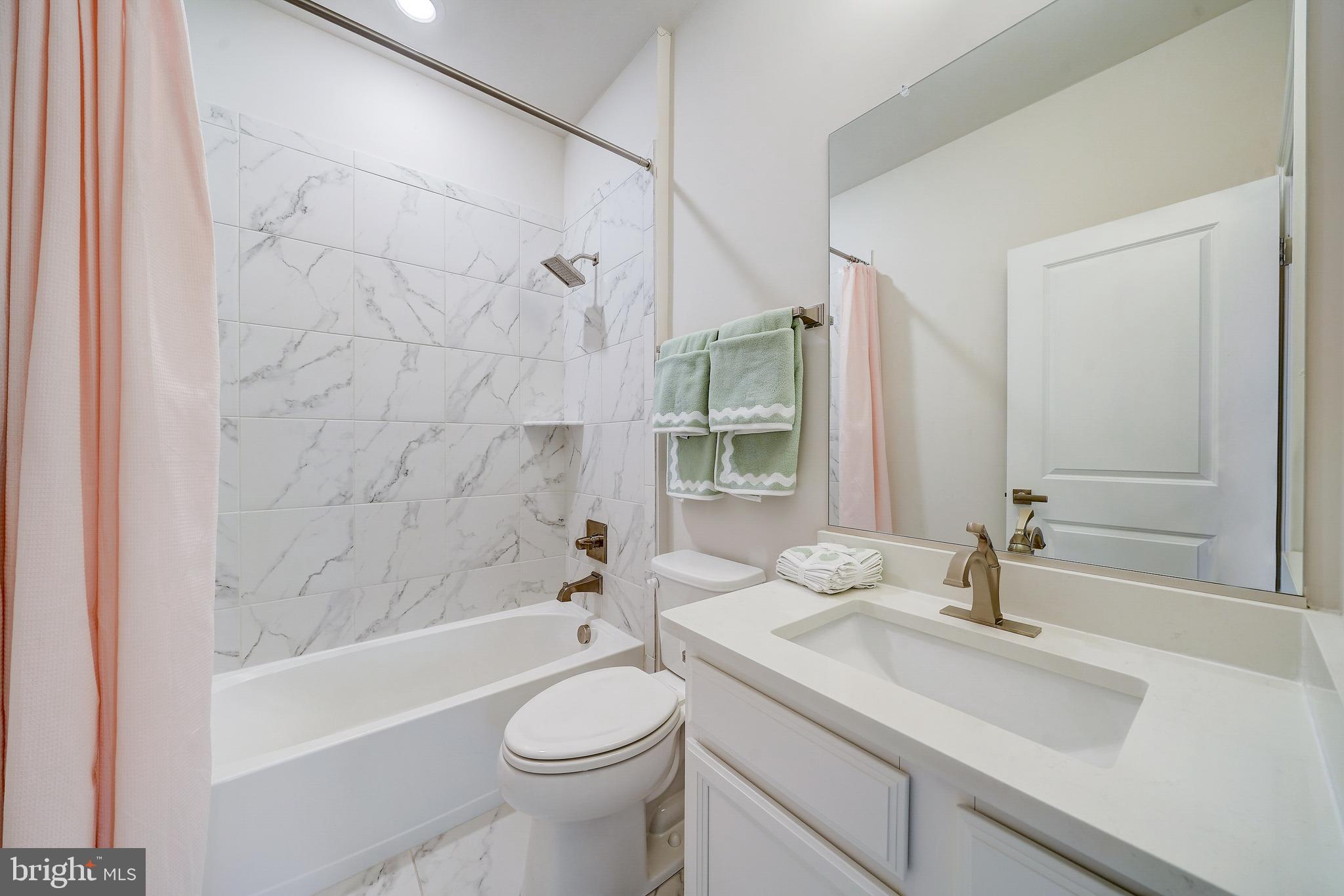 6 Gershwin Drive West Chester, PA 19380 - Photo 55 of 79 a bathroom with a granite countertop sink a toilet a mirror a bathtub and shower