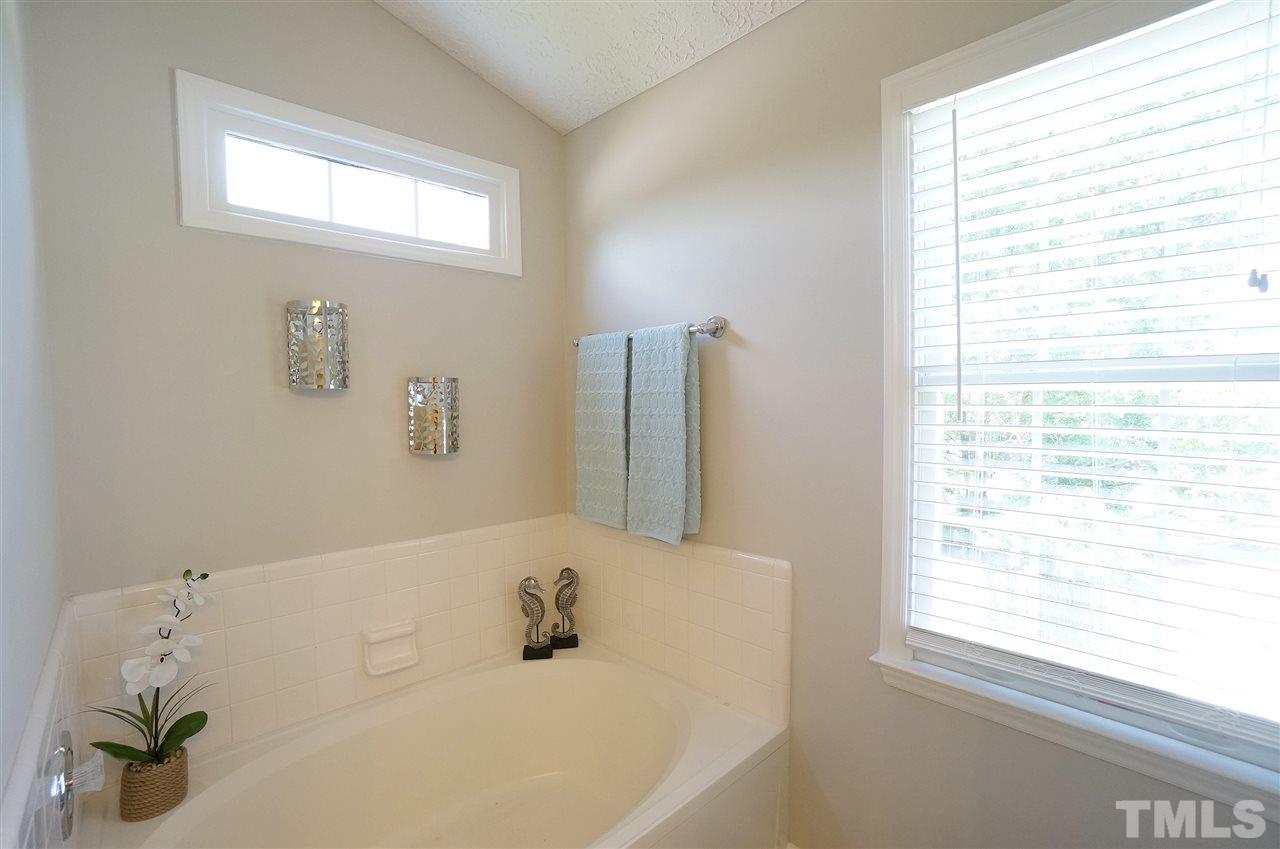 5401 Spring Pines Way Raleigh, NC 27616 - Photo 12 of 16 a bathroom with a bathtub and a window