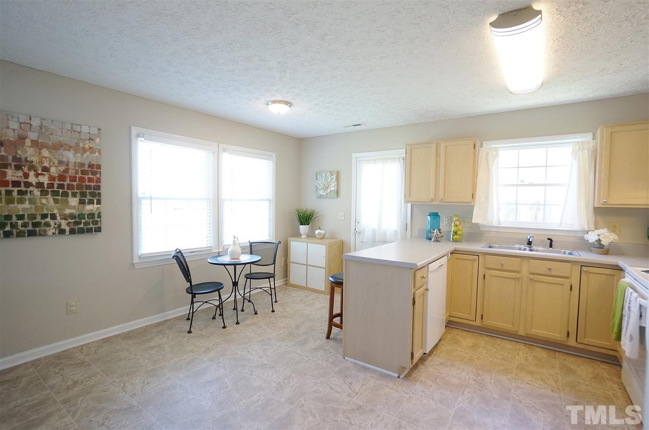 5401 Spring Pines Way Raleigh, NC 27616 - Photo 4 of 16 a kitchen with a stove a sink a dining table and chairs