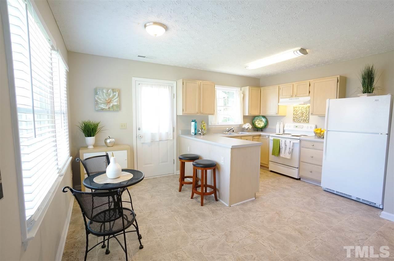 5401 Spring Pines Way Raleigh, NC 27616 - Photo 6 of 16 a kitchen that has a dining table chairs and a refrigerator