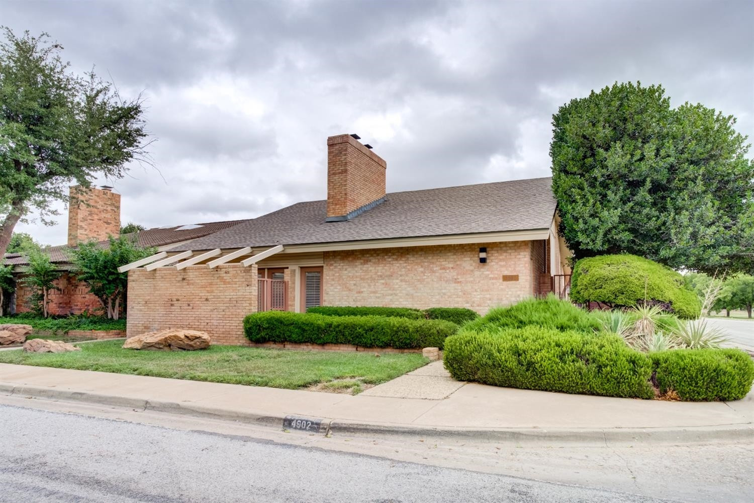 4902 92nd Street Lubbock, TX 79424 - Photo 3 of 44 a front view of a house with a yard and garage