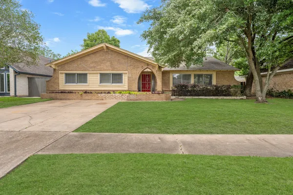 a front view of a house with a garden and trees