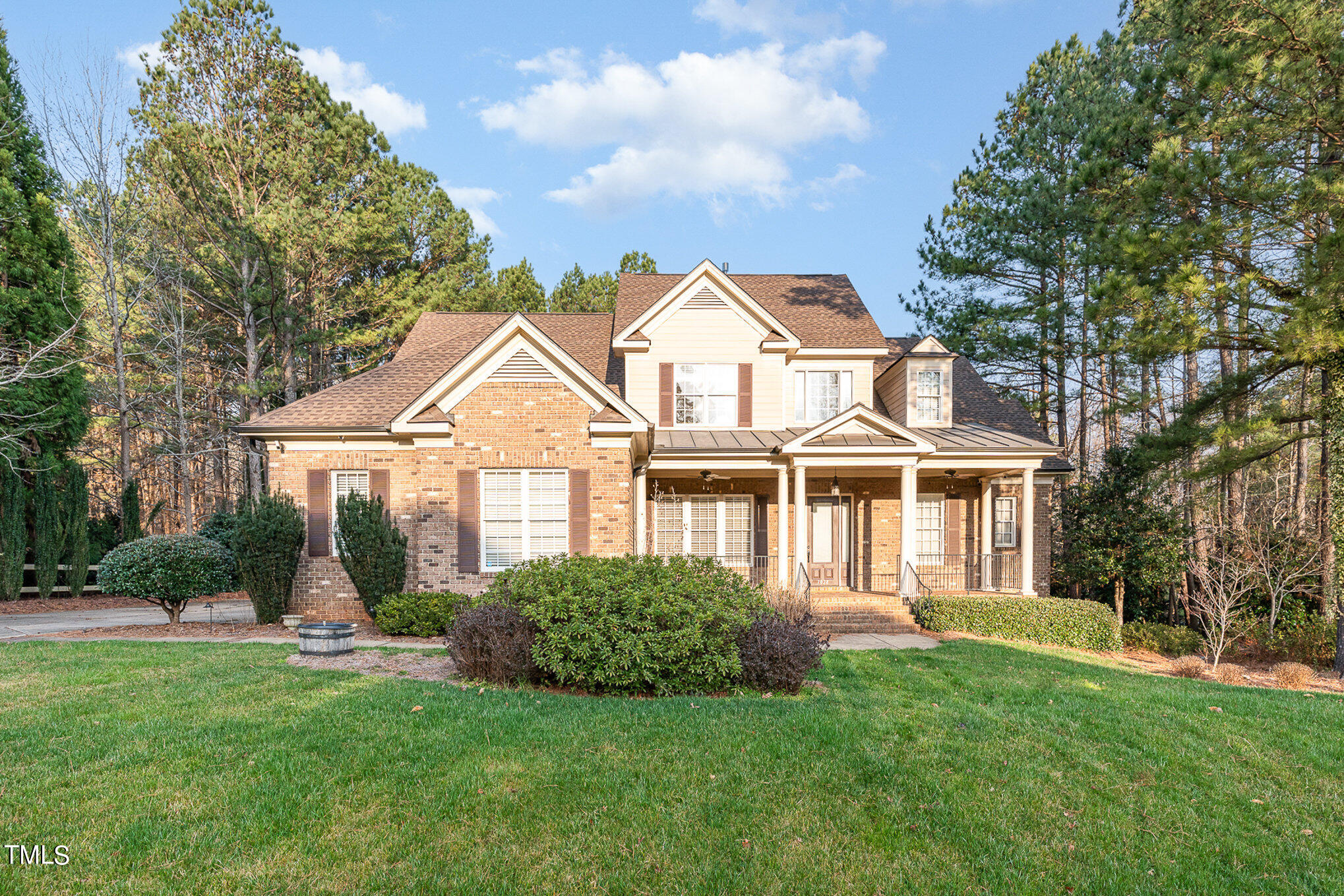 a front view of a house with a garden and plants