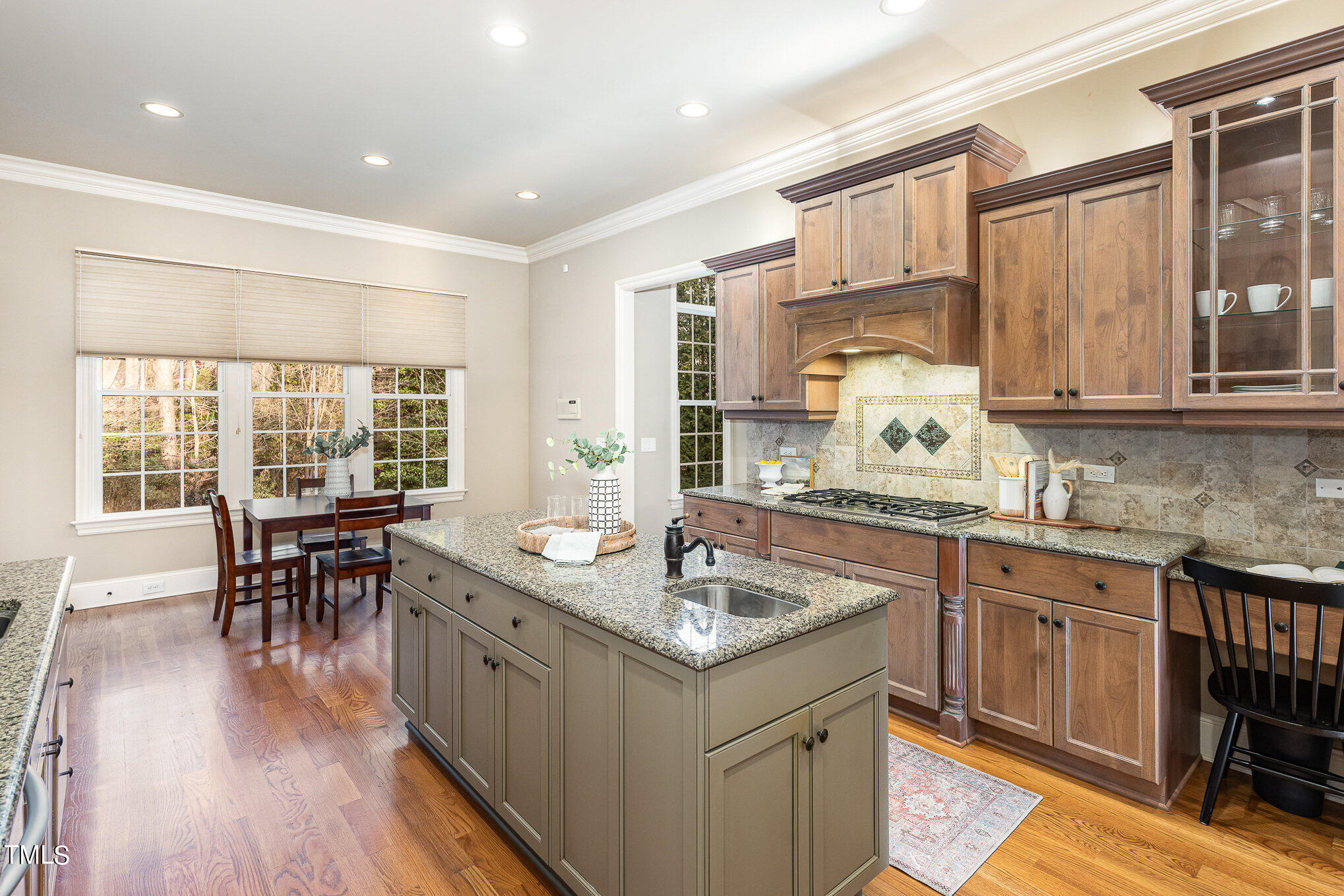 3028 Wyntree Ridge Way Raleigh, NC 27606 - Photo 9 of 39 a kitchen with counter top space sink dining table and wooden floor