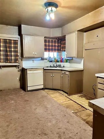 a kitchen with stainless steel appliances granite countertop a sink window and cabinets