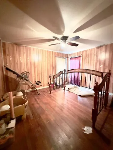a view of an empty room with furniture wooden floor and windows