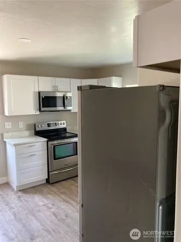 a kitchen with stainless steel appliances a refrigerator stove and microwave