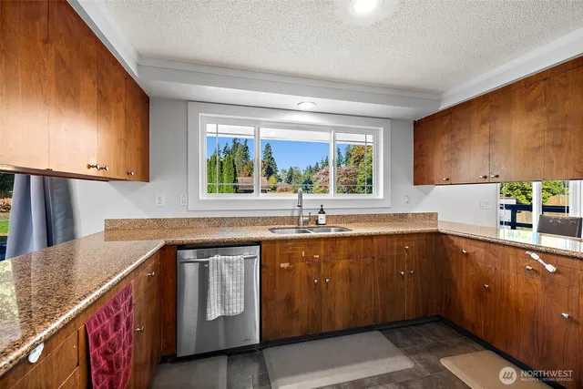 a kitchen with stainless steel appliances granite countertop a stove a sink and a microwave
