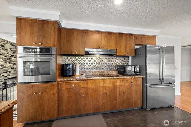 a kitchen with stainless steel appliances wooden cabinets and a sink