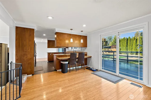 a view of a living room with kitchen view and a flat screen tv