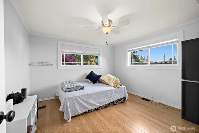 an empty room with wooden floor and a ceiling fan