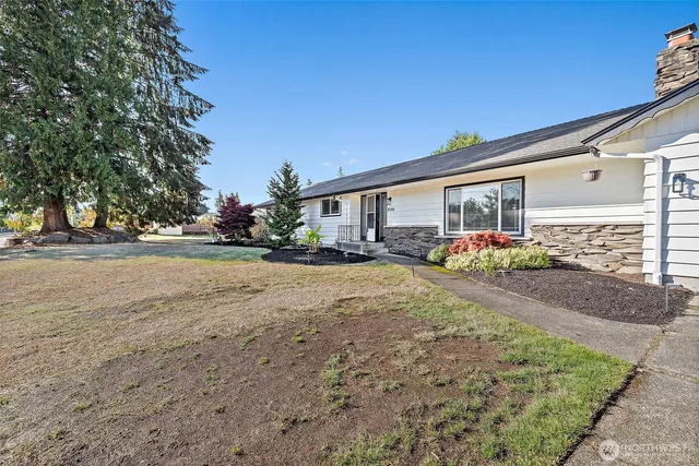 a front view of a house with a yard and potted plants