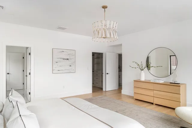 a bedroom with a bed and a chandelier