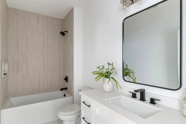 a bathroom with a sink a toilet tub and shower
