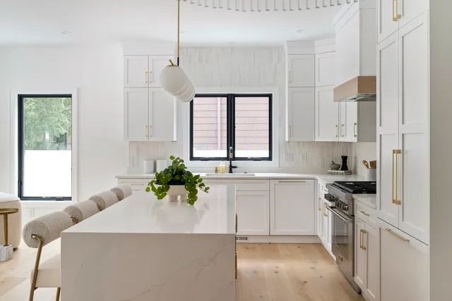 a kitchen with a white stove top oven and white cabinets