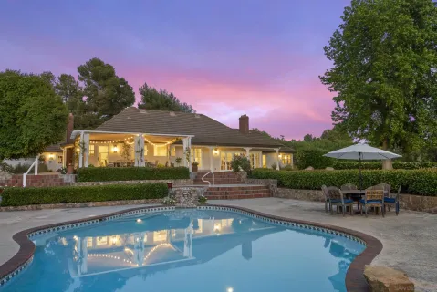 a view of a swimming pool with a patio and a yard