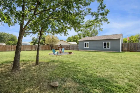 a backyard of a house with table and chairs