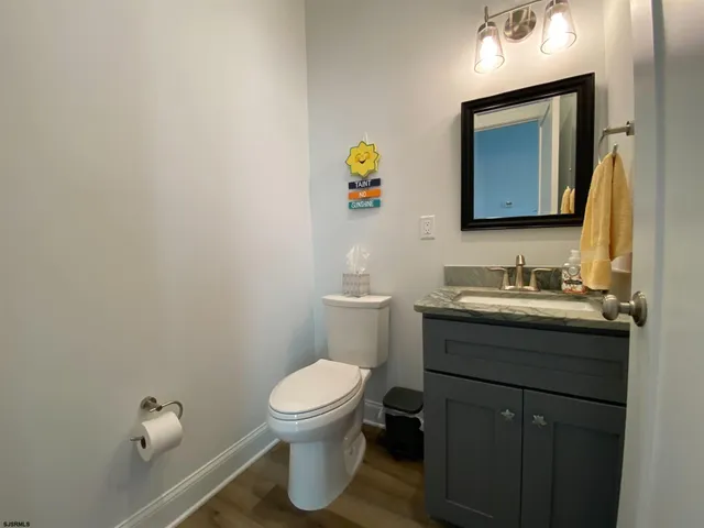 a bathroom with a granite countertop toilet sink and mirror