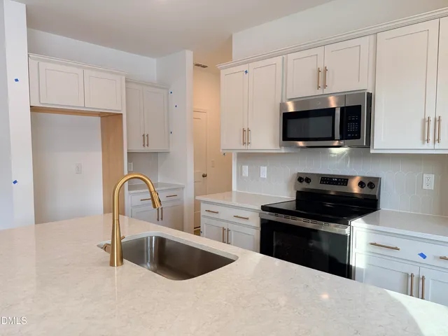 a kitchen with a sink stove and cabinets