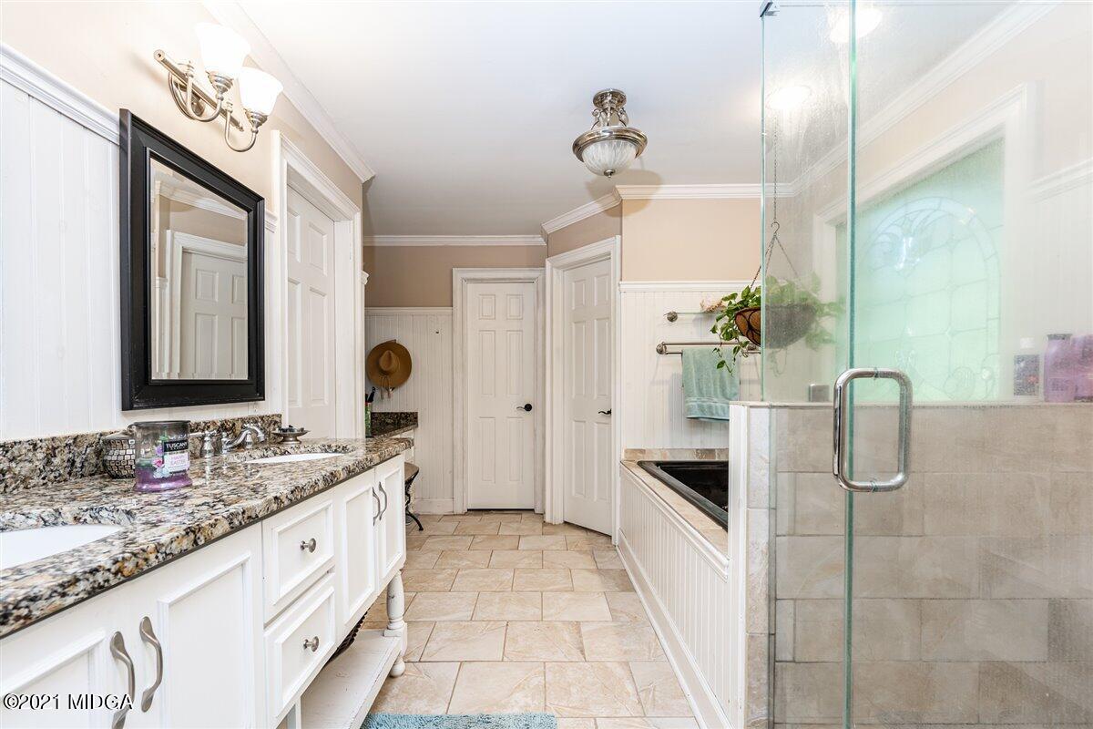 7798 Zebulon Road Macon, GA 31220 - Photo 10 of 35 a spacious bathroom with a granite countertop sink a mirror and shower