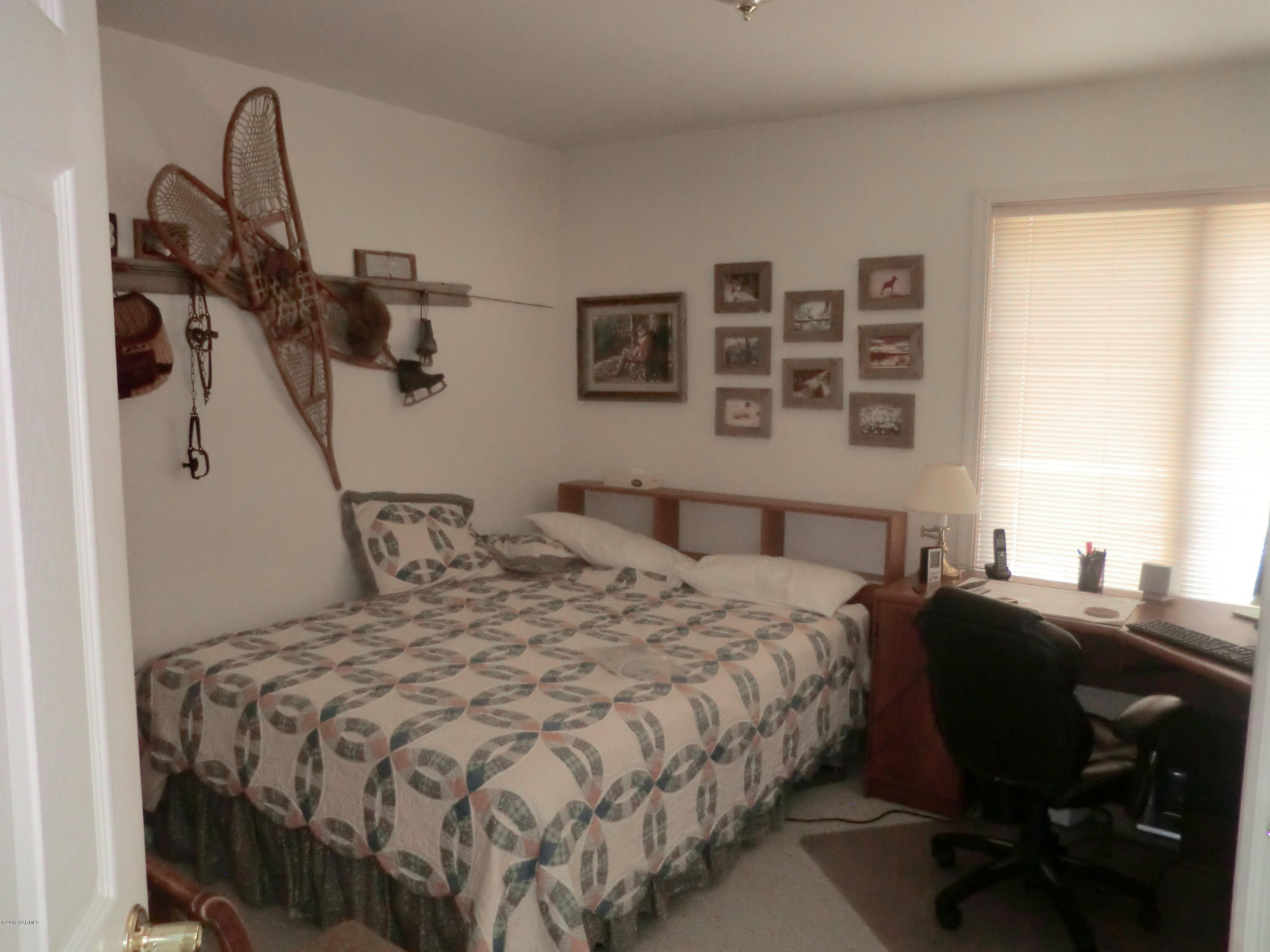 14721 Fisk Road Yakima, WA 98908 - Photo 11 of 20 a bedroom with a bed and a dresser next to a window