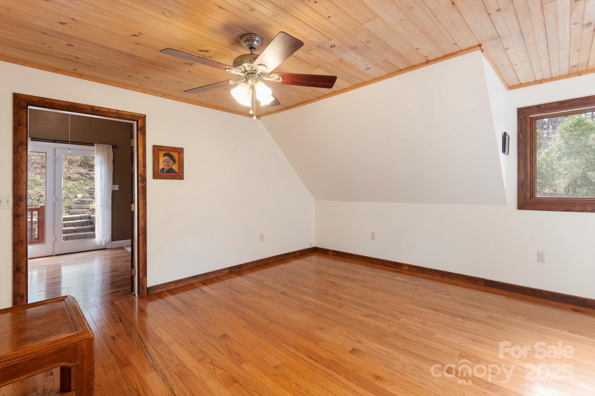 1506 Lynn Road Columbus, NC 28722 - Photo 11 of 30 a view of an empty room with wooden floor and a chandelier