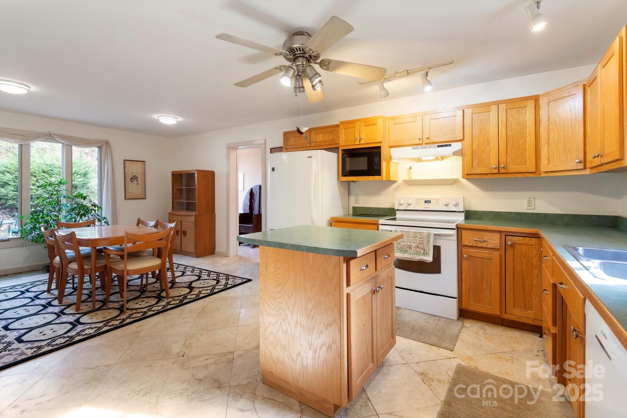 1506 Lynn Road Columbus, NC 28722 - Photo 17 of 30 a kitchen with stainless steel appliances granite countertop a stove refrigerator sink and chairs