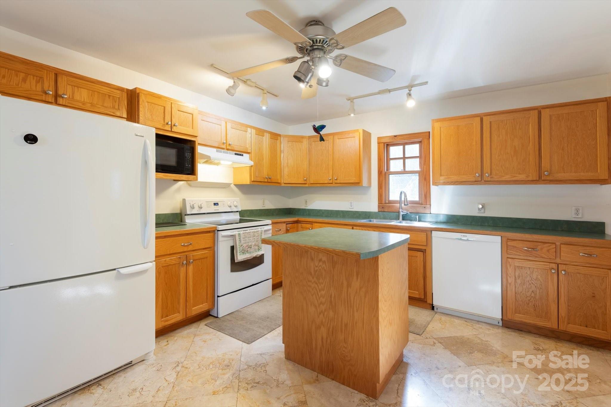1506 Lynn Road Columbus, NC 28722 - Photo 18 of 30 a kitchen with stainless steel appliances granite countertop a sink a stove a refrigerator cabinets and a window
