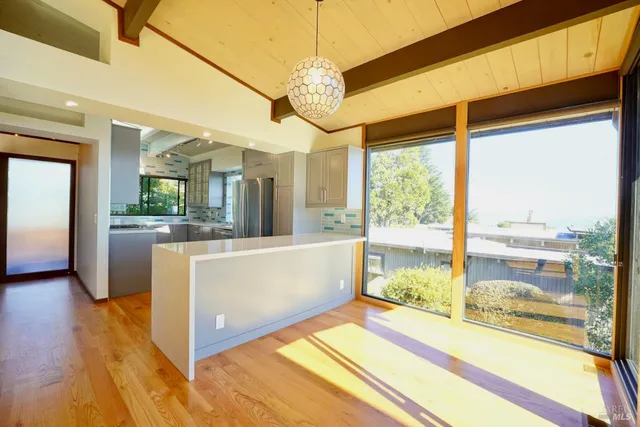 a view of a big room with wooden floor and windows