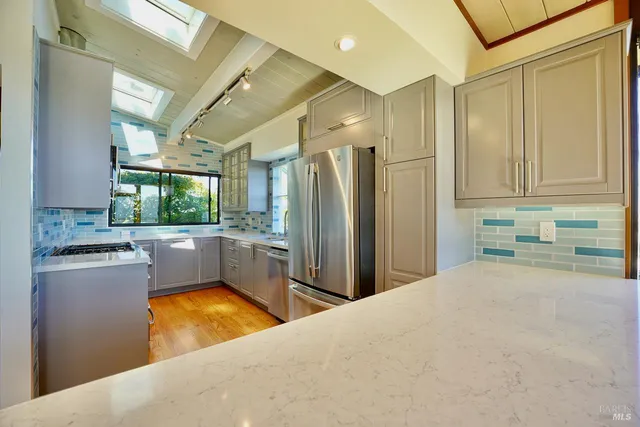 a large kitchen with stainless steel appliances granite countertop a refrigerator and a sink