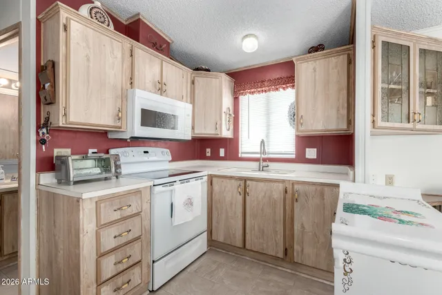a kitchen with cabinets a sink and chairs