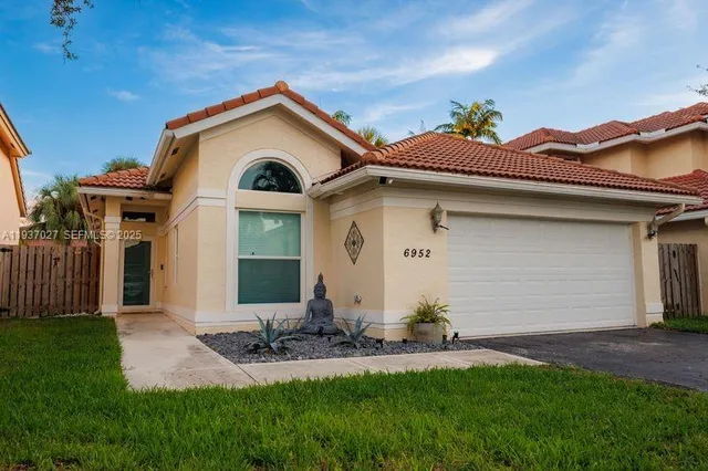 a front view of a house with a yard and garage