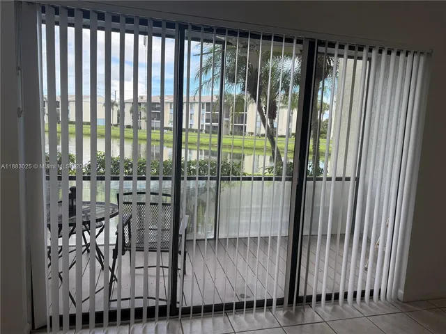 a view of a room with a large window and furniture