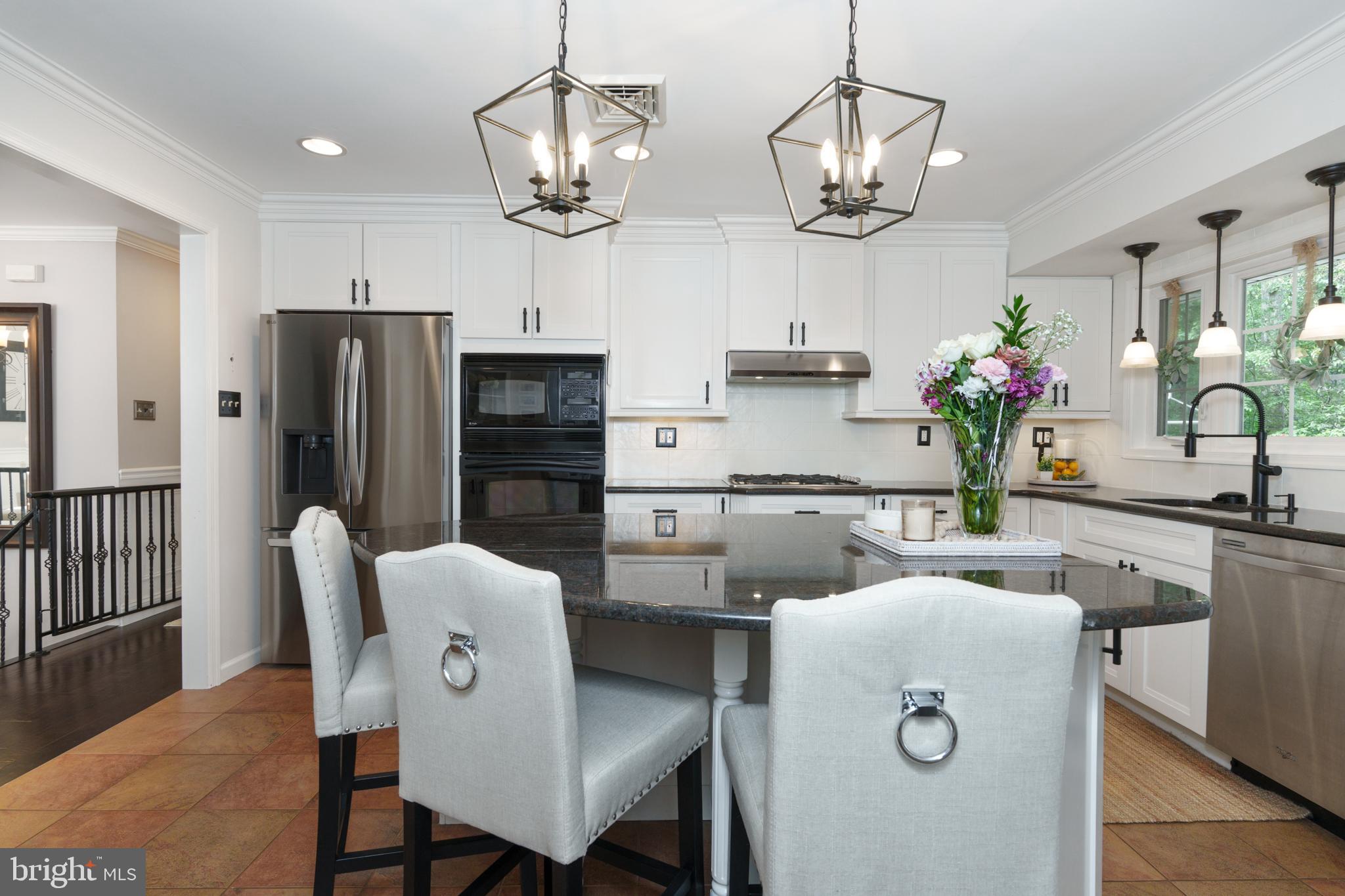 1411 Greenhill Road West Chester, PA 19380 - Photo 15 of 40 a dining room with wooden floor a chandelier a kitchen view and stainless steel appliances