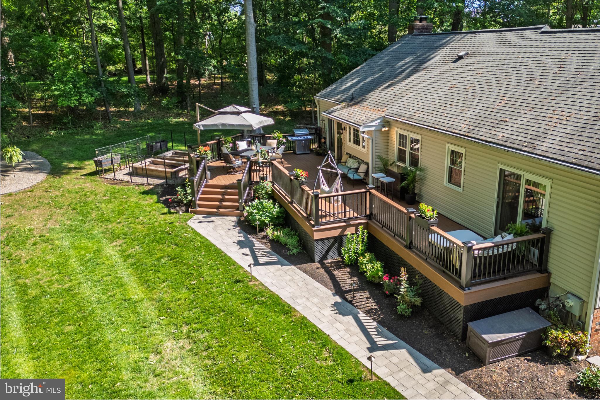 1411 Greenhill Road West Chester, PA 19380 - Photo 3 of 40 a backyard of a house with table and chairs under an umbrella
