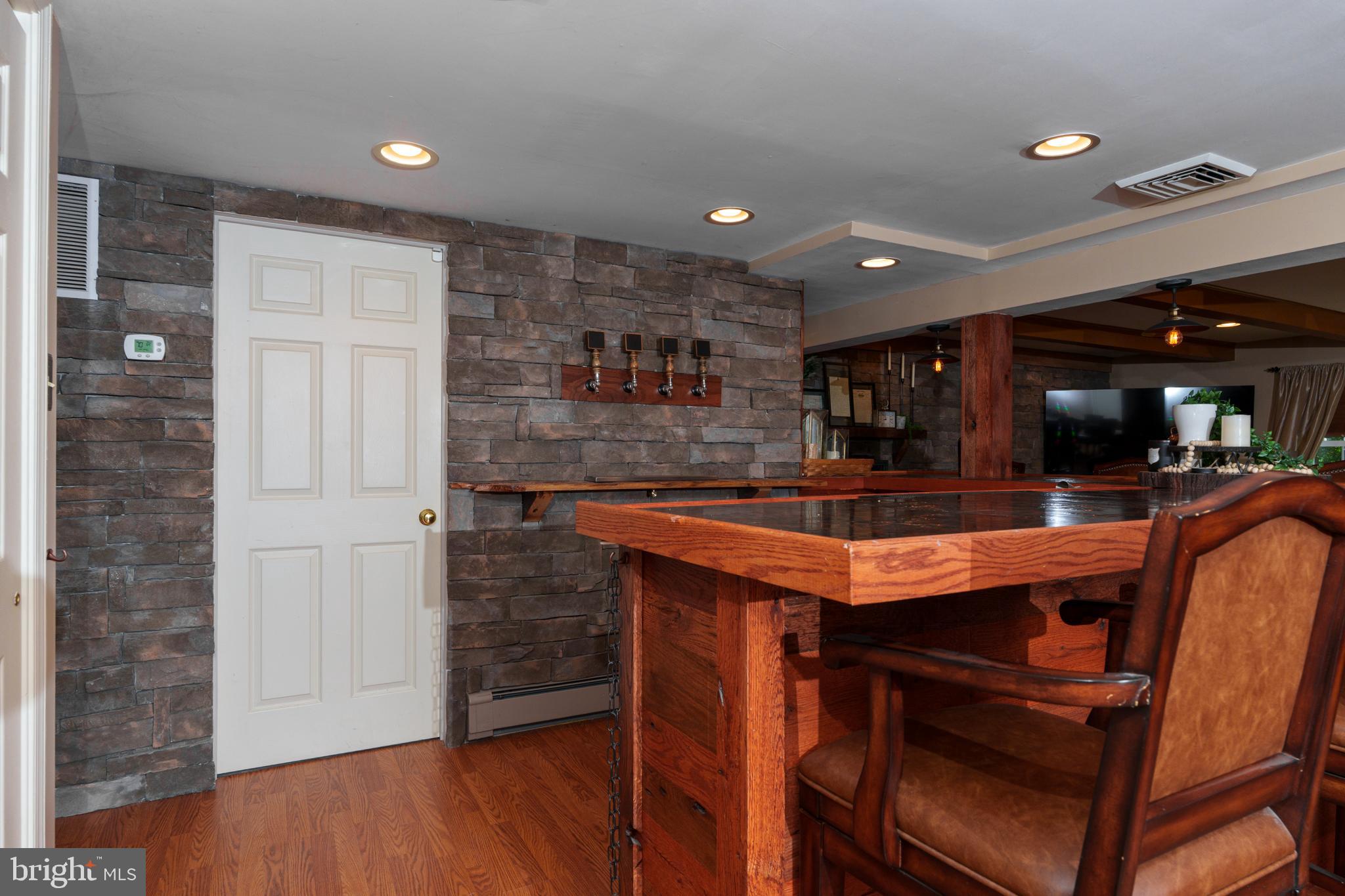 1411 Greenhill Road West Chester, PA 19380 - Photo 32 of 40 a room with stainless steel appliances kitchen island granite countertop a table chairs in it and wooden floors