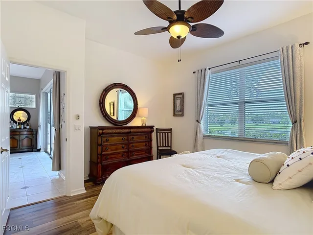 a bedroom with a bed a dresser and a chandelier