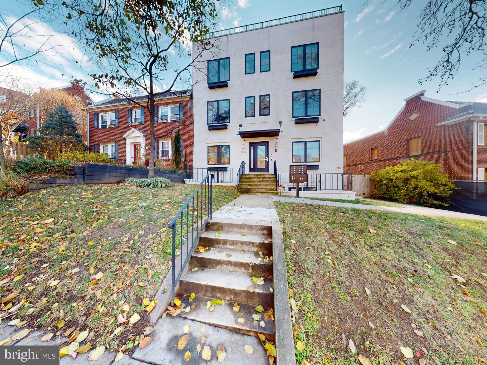 2642 39th Street Northwest, Unit 2 Washington, DC 20007 - Photo 19 of 25 a front view of a residential apartment building with a yard