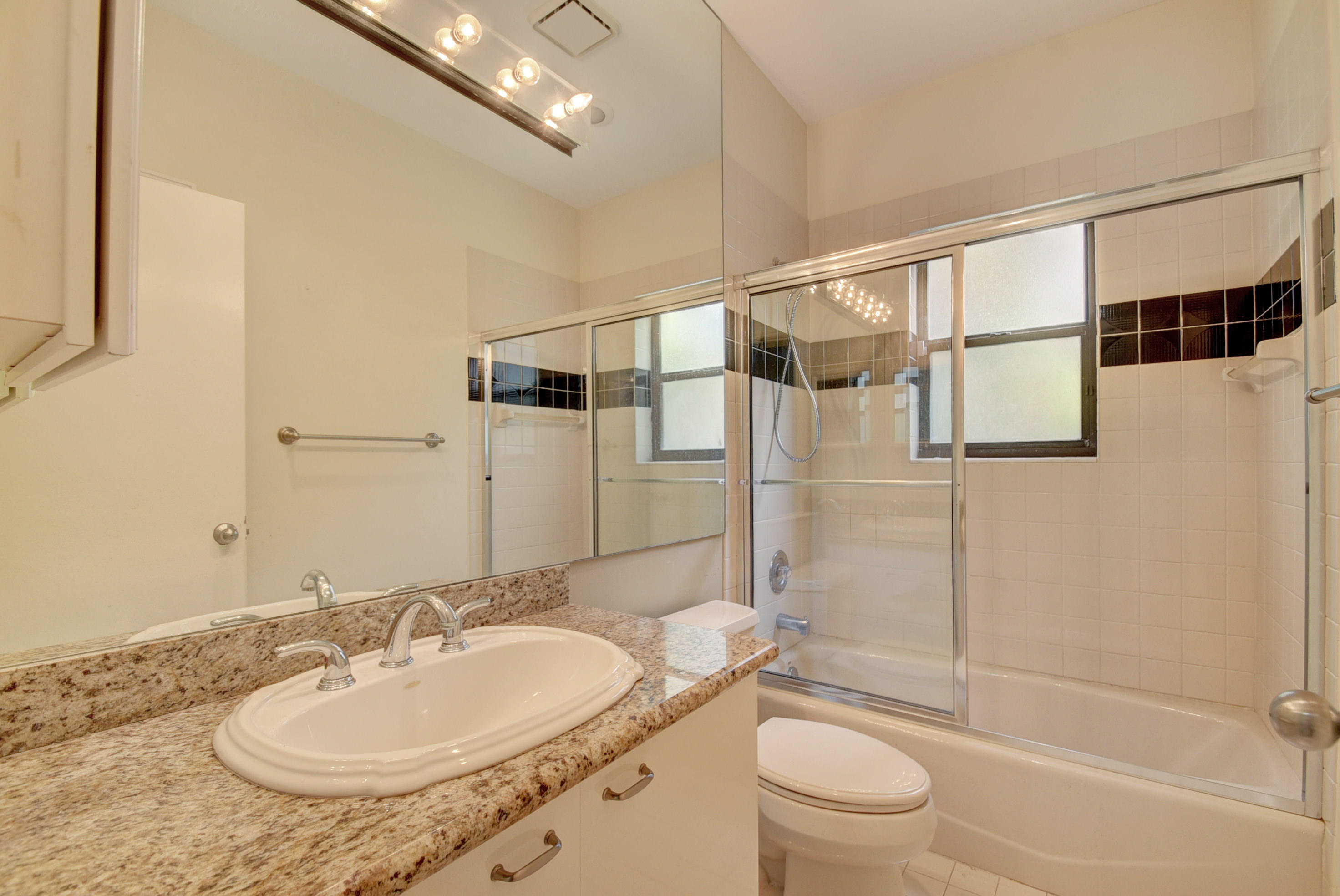 4426 Northwest 29th Way Boca Raton, FL 33434 - Photo 14 of 23 a bathroom with a sink toilet a mirror and shower