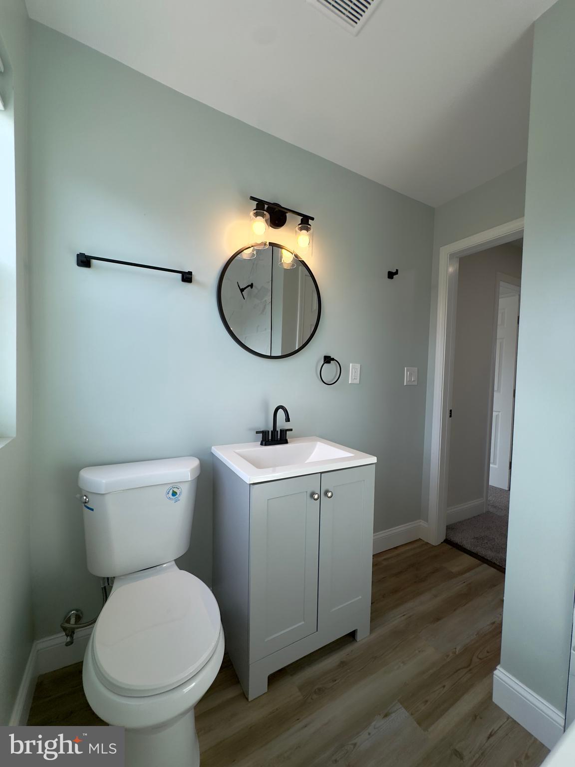 5430 Whitlock Road Baltimore, MD 21229 - Photo 18 of 30 a bathroom with a granite countertop toilet sink and mirror
