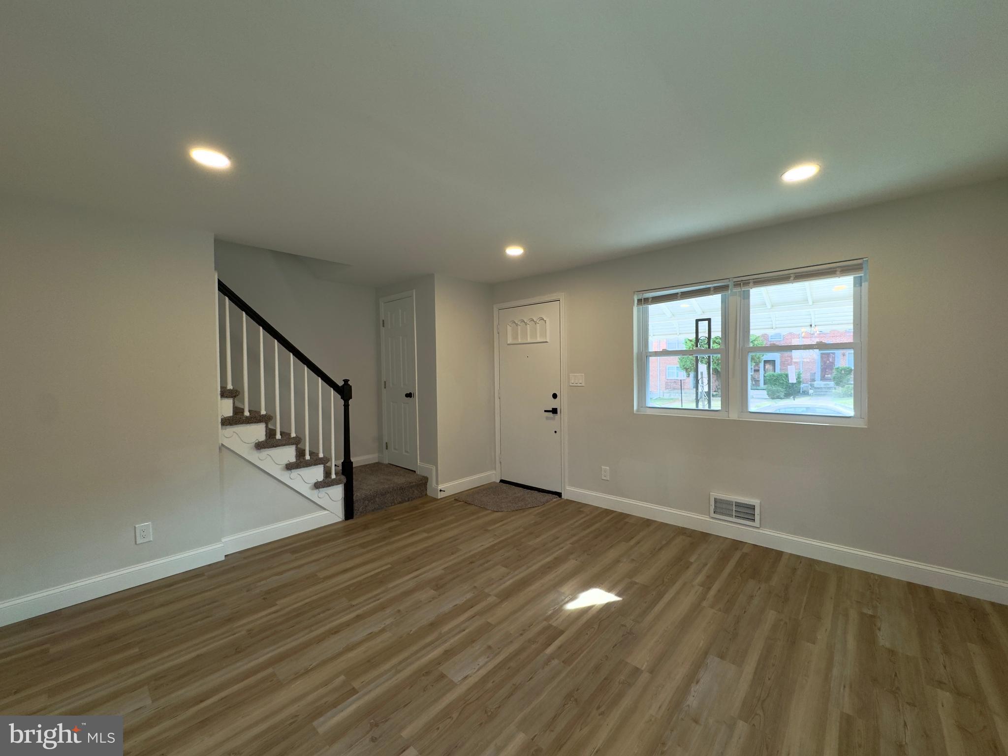 5430 Whitlock Road Baltimore, MD 21229 - Photo 22 of 30 a view of an empty room with wooden floor and a window