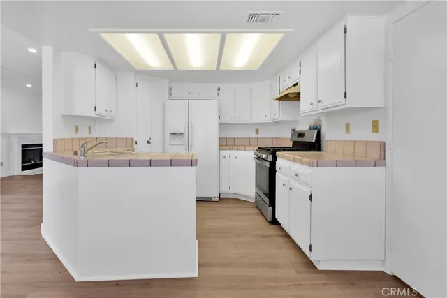a kitchen with cabinets a sink and white stainless steel appliances